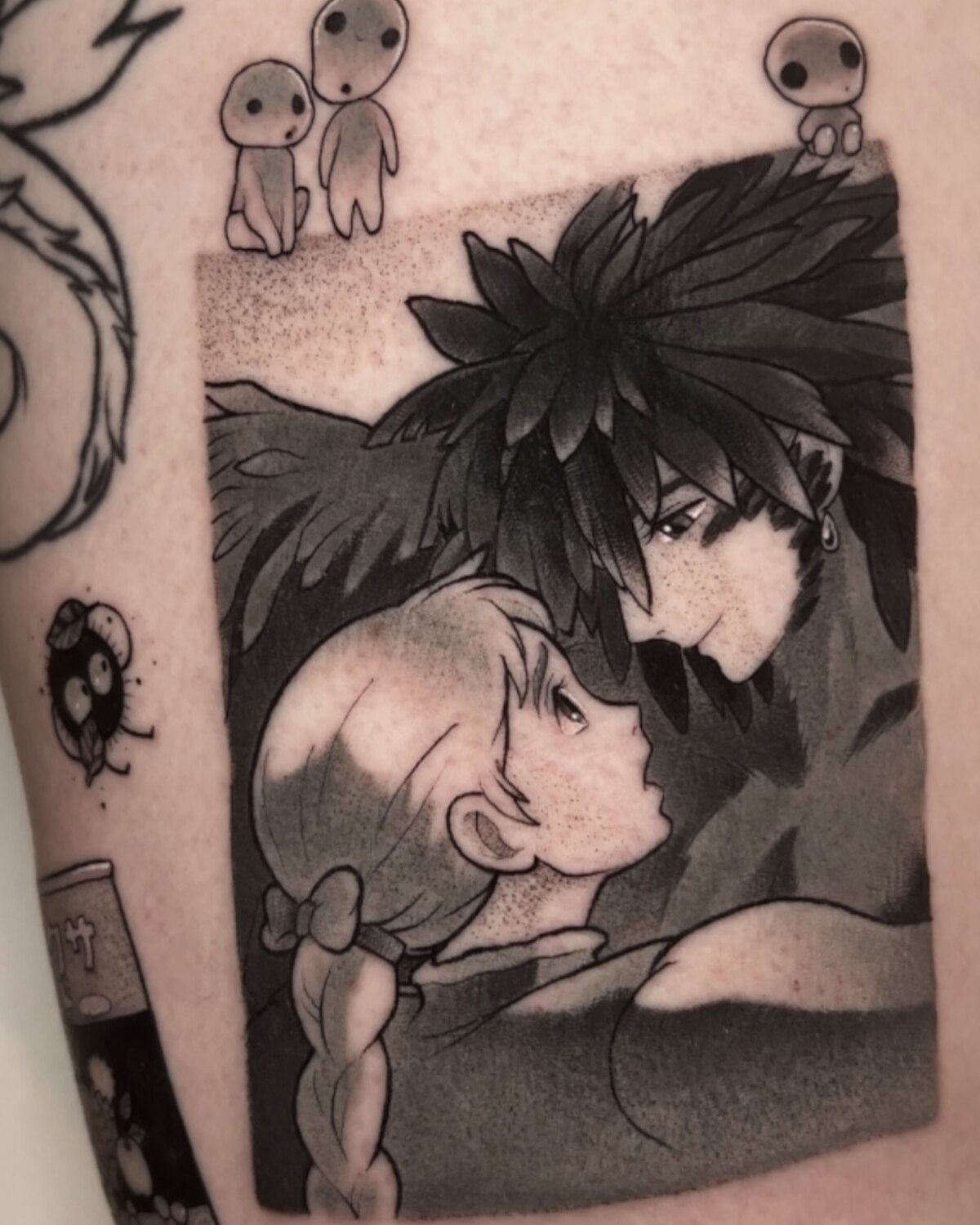 Tatouage noir et gris inspiré de Ghibli sur l'avant-bras